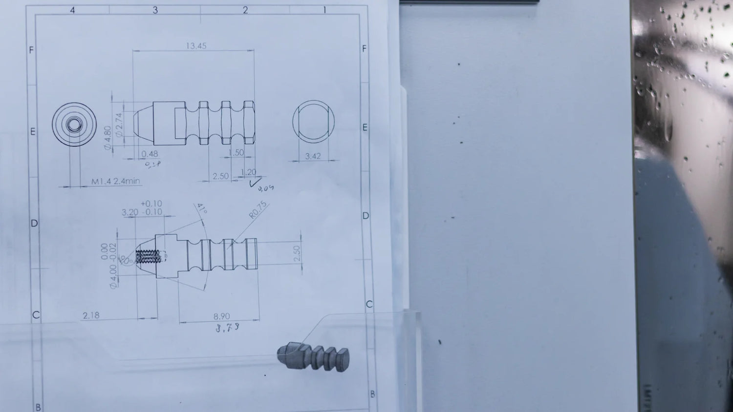 Technical drawing of a dental implant component displayed near CNC manufacturing equipment during the OEM production process.