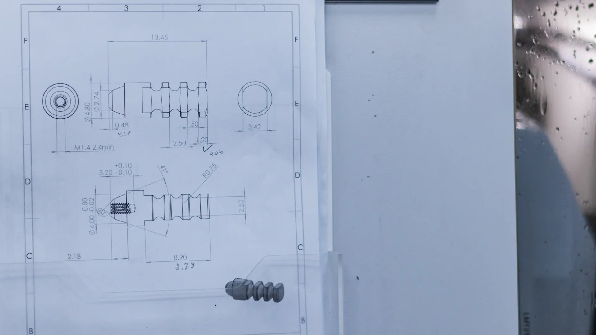 Technical drawing of a dental implant component displayed near CNC manufacturing equipment during the OEM production process.