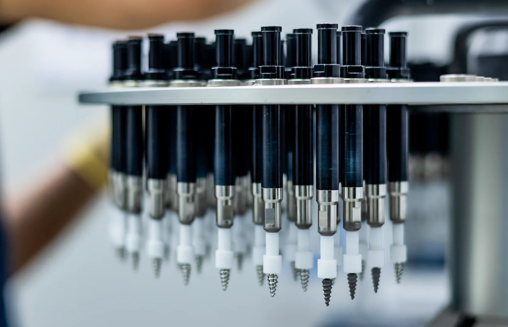 One-piece dental implants arranged in production holders during manufacturing.
