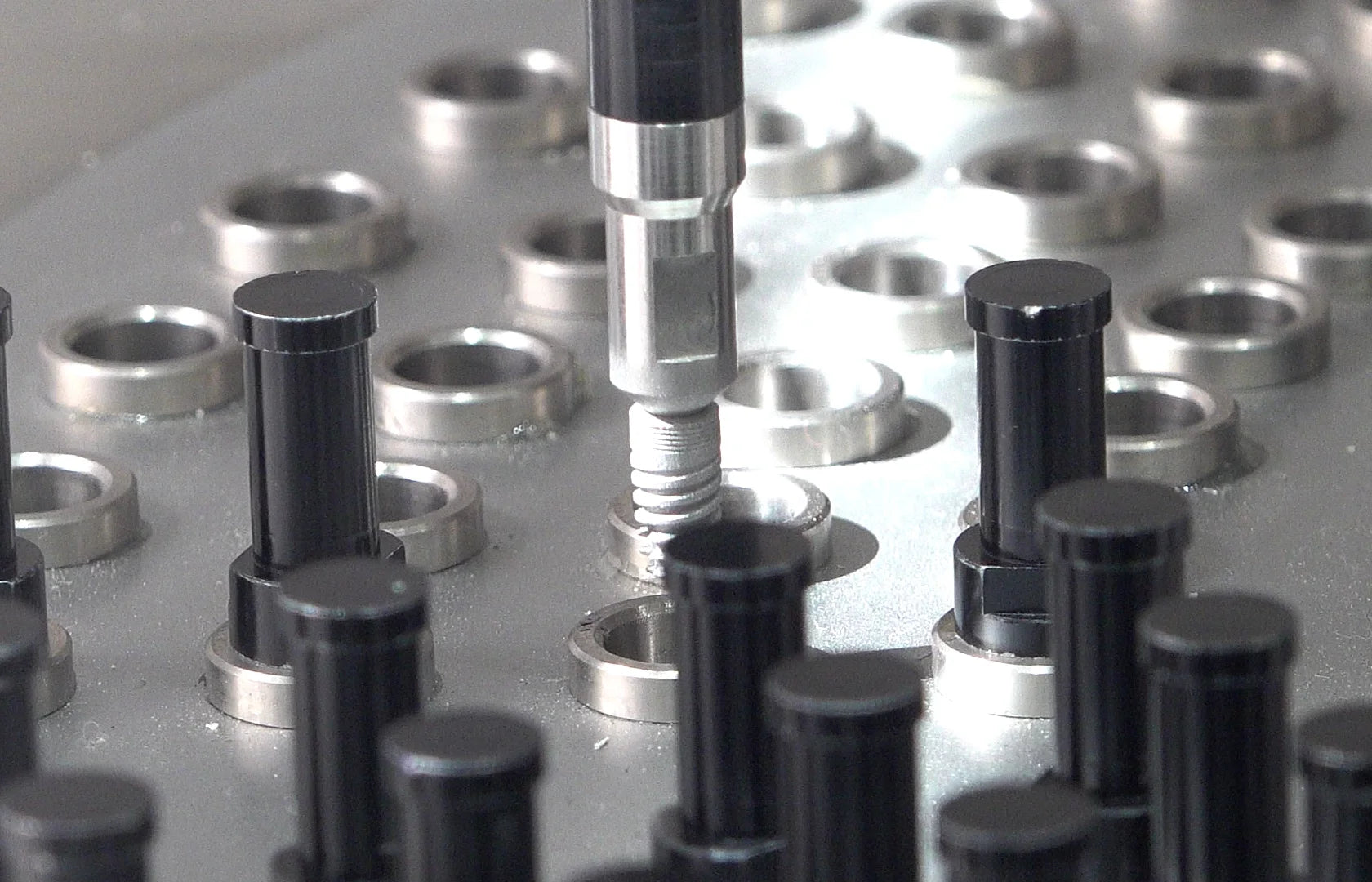 Dental implant components undergoing SLA surface treatment during the production process.