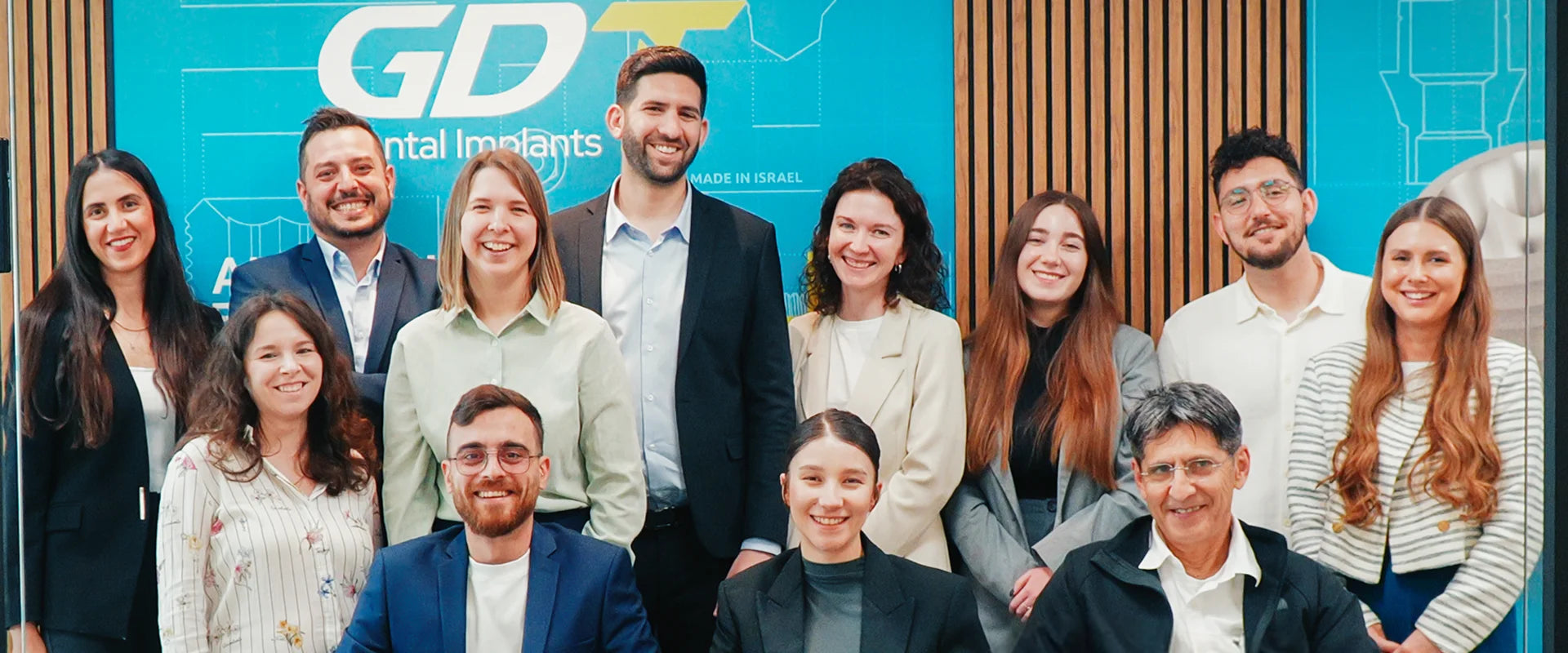 Group of people posing in front of a GDT Dental Implants banner
