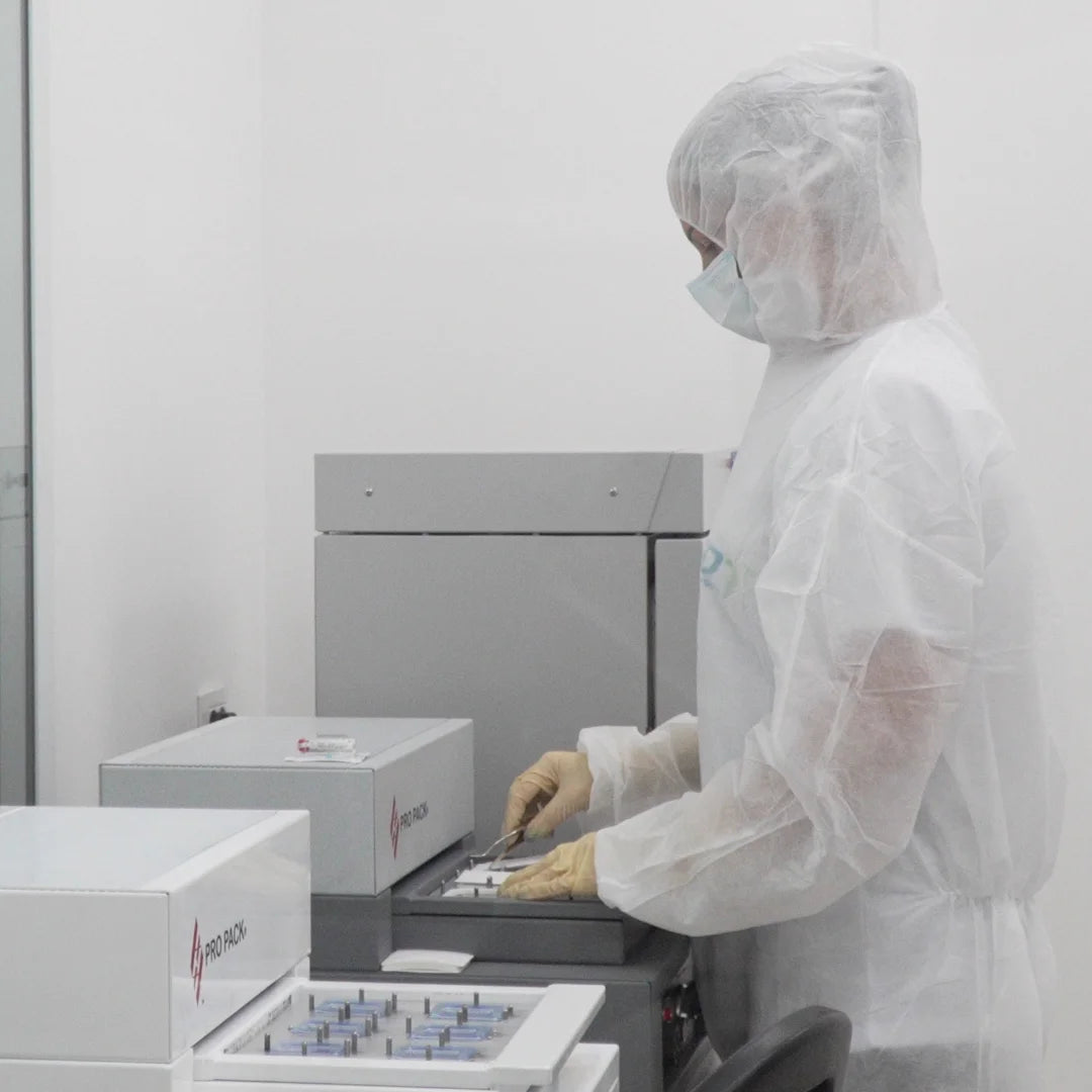 Cleanroom technician operating sterile blister packaging equipment for GDT dental implant products.