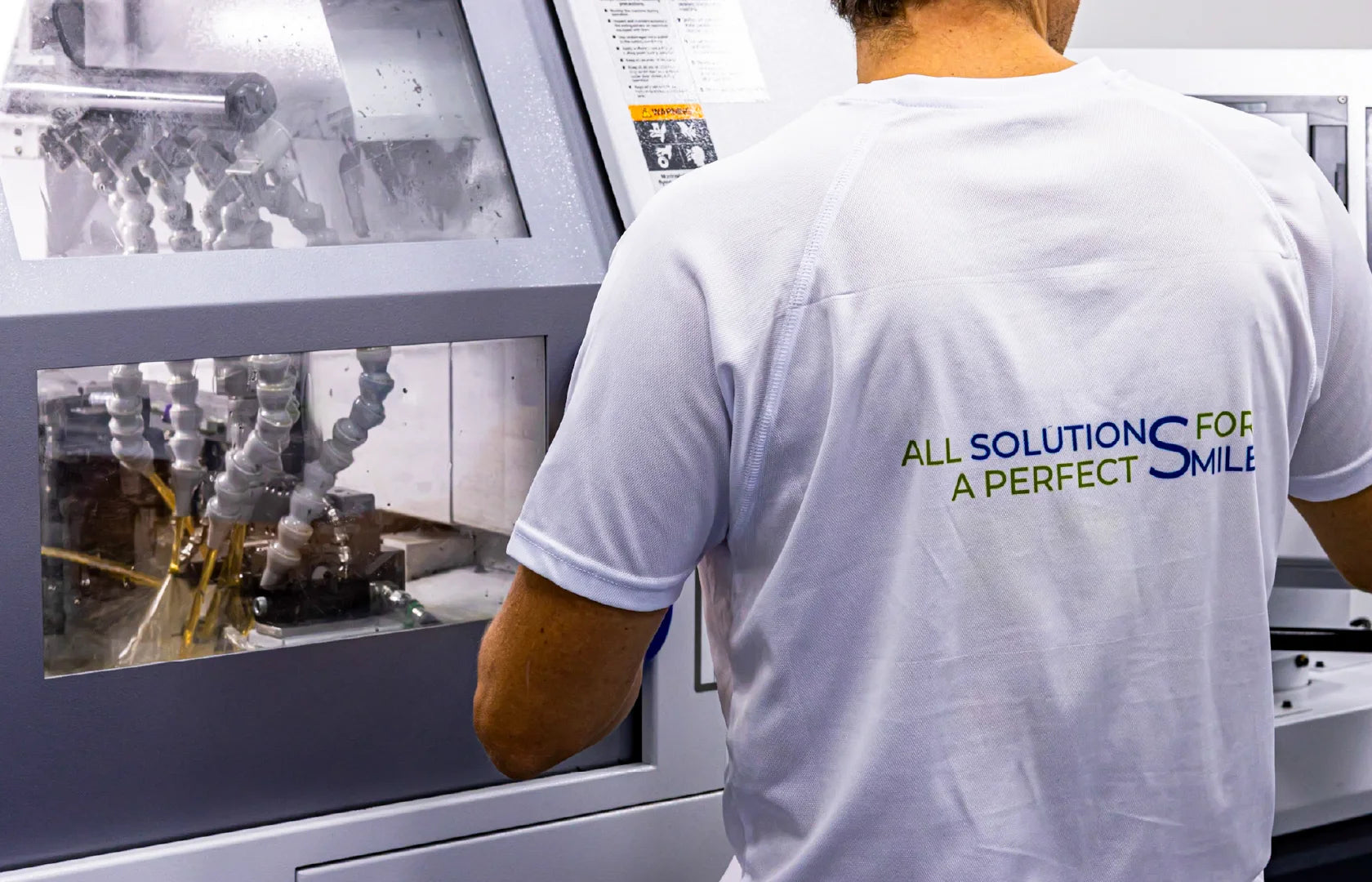 GDT production worker operating dental implant manufacturing equipment.